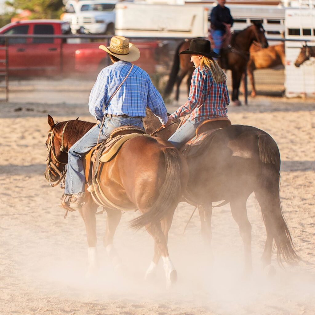 Cowboy and Cowgirl riding horses and holding hands